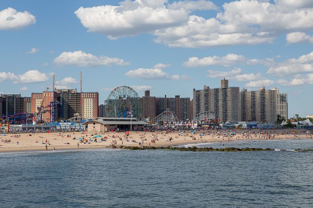People, masked and unmasked, on the Coney Island beach (from a distance)